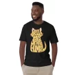 Man wearing a black Proud Spare Human Orange Tabby Cat T-Shirt, smiling with hands in pockets.