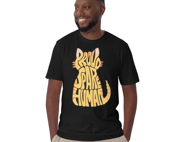 Proud Spare Human Orange Tabby Cat Shirt - Black - Man Smiling Man wearing a black Proud Spare Human Orange Tabby Cat T-Shirt, smiling with hands in pockets.