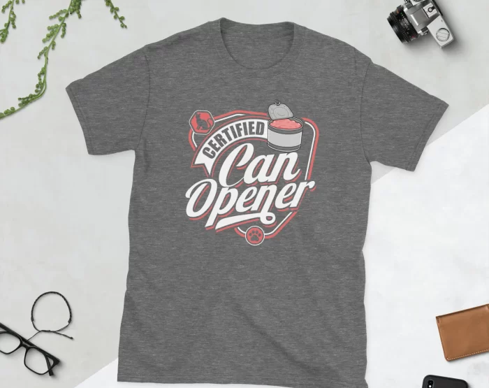 Certified Can Opener Shirt Flat Lay Graphite Heather Flat lay of Graphite Heather Certified Can Opener tee with plant and scissors on white background