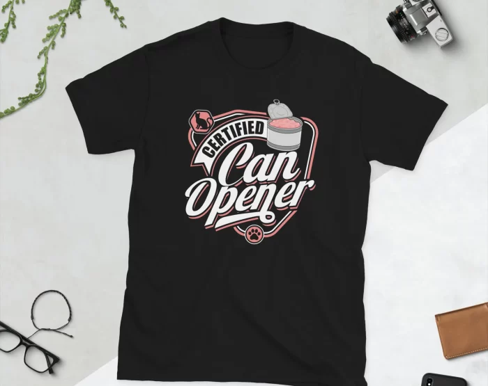 Certified Can Opener T-Shirt Flat Lay Black Flat lay of black Certified Can Opener cat parent shirt styled with scissors and greenery