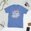 Flat lay of Heather Royal Certified Can Opener cat tee styled with plant and accessories