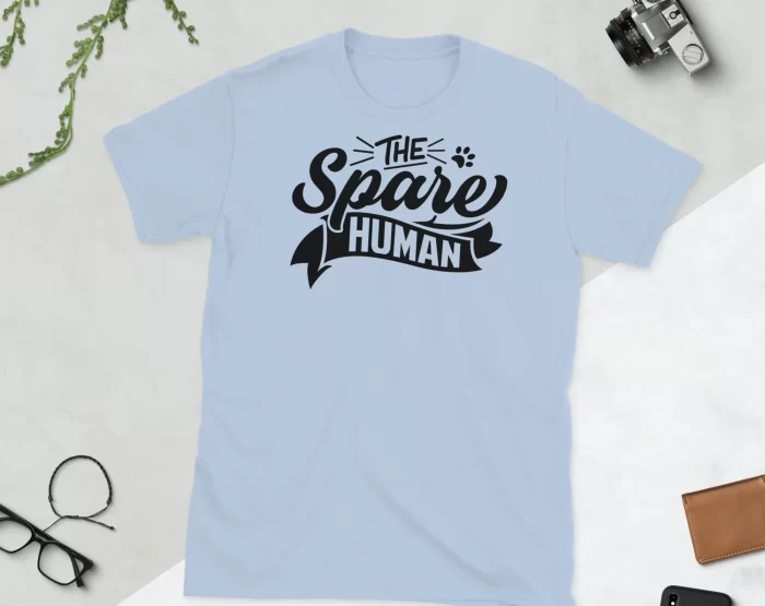 Light Blue Spare Human Shirt Flat Lay Flat lay of light blue "The Spare Human" minimalist t-shirt with scissors and plant on white background