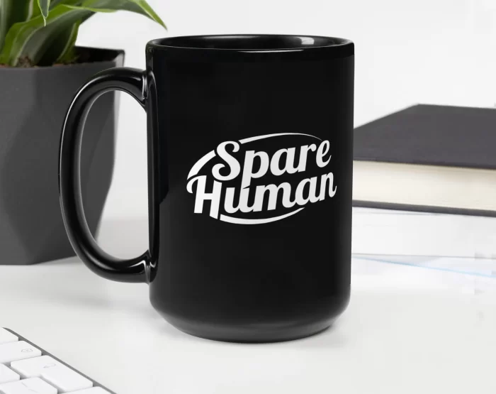 black-glossy-mug-black-handle-on-left Black Spare Human mug on white desk next to computer and green plant