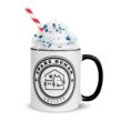 White ceramic mug with black handle and Spare Human Society logo, topped with whipped cream and sprinkles