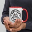 Hands holding red and white mug with circular Spare Human Society pet graphic for cat and dog owners.