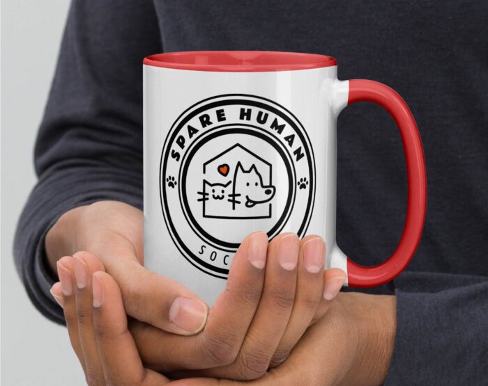 funny-animal-lover-coffee-mug-red-cat-dog-graphic. Hands holding red and white mug with circular Spare Human Society pet graphic for cat and dog owners.
