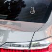 Funny cat parent sticker placed on black car window showing Proud Spare Human design