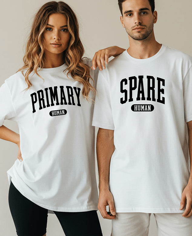 Two white cotton T-shirts with bold black collegiate lettering reading “PRIMARY HUMAN” and “SPARE HUMAN,” worn by a smiling couple.